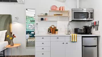 A compact kitchenette with a microwave, toaster, and refrigerator.