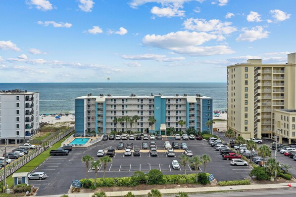 Un hotel con piscina, parcheggio e vista sull'oceano.
