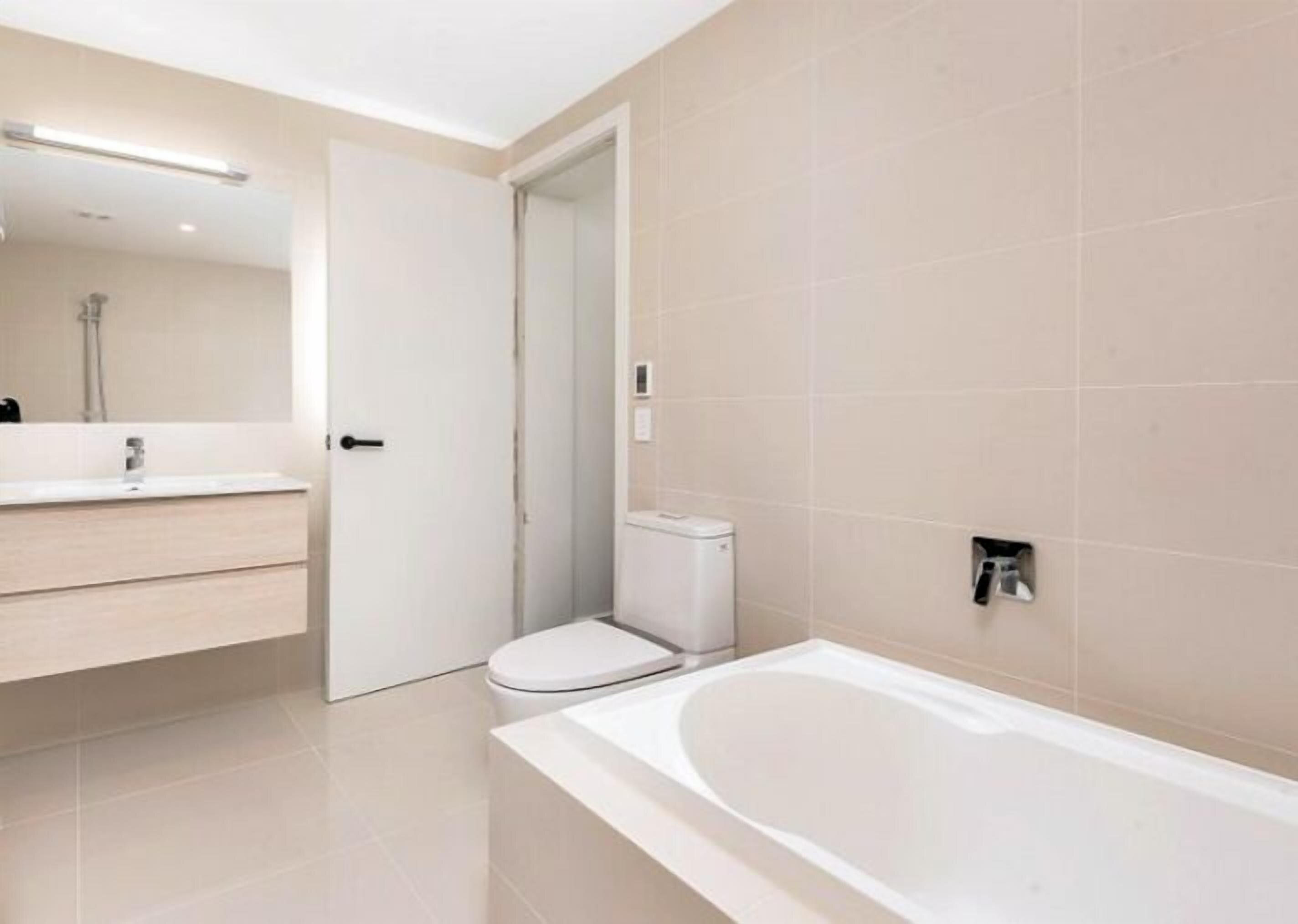 Ein modernes Badezimmer mit Badewanne, Toilette und Waschtisch.