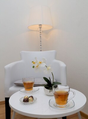 A small round table with two glasses of tea and a plate of chocolates, a white chair, and a potted orchid. - Room in Dubrovnik with Air condition, WIFI, Washing machine (4246-3) (Dubrovnik)