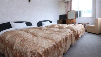 Une chambre d’hôtel avec un grand lit, un bureau, une chaise et une fenêtre.