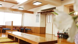 Une pièce de style japonais traditionnel, avec des tatamis, des meubles en bois et une porte coulissante.