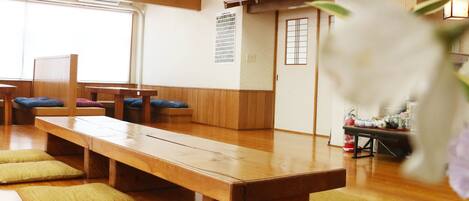 Una habitación japonesa tradicional con esteras de tatami, muebles de madera y una puerta corredera.