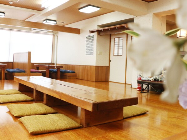 A traditional Japanese room with tatami mats, wooden furniture, and a sliding door. - Sunflower City Hotel (Setouchi)