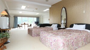 Une chambre d’hôtel avec deux lits, un coin repas et une grande fenêtre.