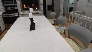 A modern kitchen with a central island, a built-in oven, a microwave, and a large window overlooking a balcony. - Spacious home 28 miles from Downtown Chicago (Hammond)
