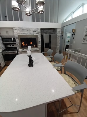 Enjoy cooking and dining in this well-equipped kitchen with a central island and fireplace.