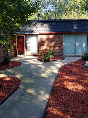Stroll through the beautifully landscaped grounds, featuring a covered driveway and a charming entrance.