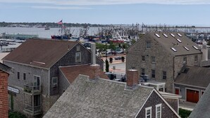 Un puerto deportivo con barcos y un edificio de piedra con tejado inclinado.