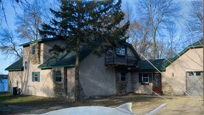 A house with a stone facade, green roof, and a large fish sculpture in the foreground. - ARTISTS & ANGLERS INN - game room - home of Madison Lake Paddlefish!! (Madison Lake)
