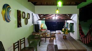 Un espace repas avec des meubles en bois, un luminaire suspendu et des éléments décoratifs sur les murs.