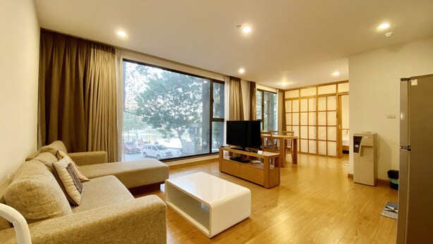 Un salon moderne avec un canapé, un téléviseur et une table basse en bois.