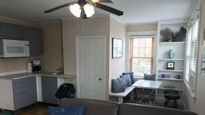 A compact living space with a kitchenette, a dining area, and a seating area with a sofa and a table.