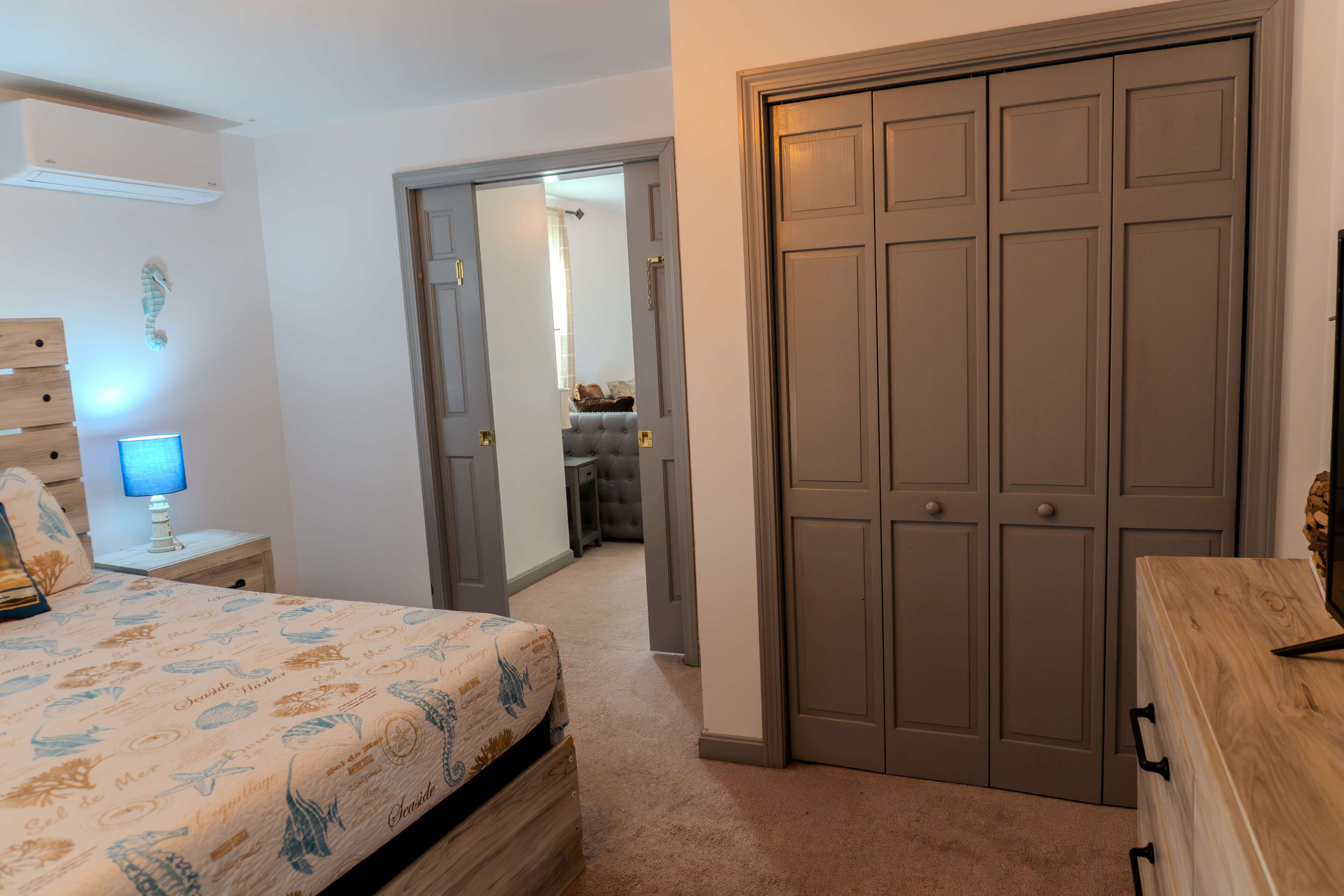A bedroom with a bed, bedside table, lamp, and a wardrobe.