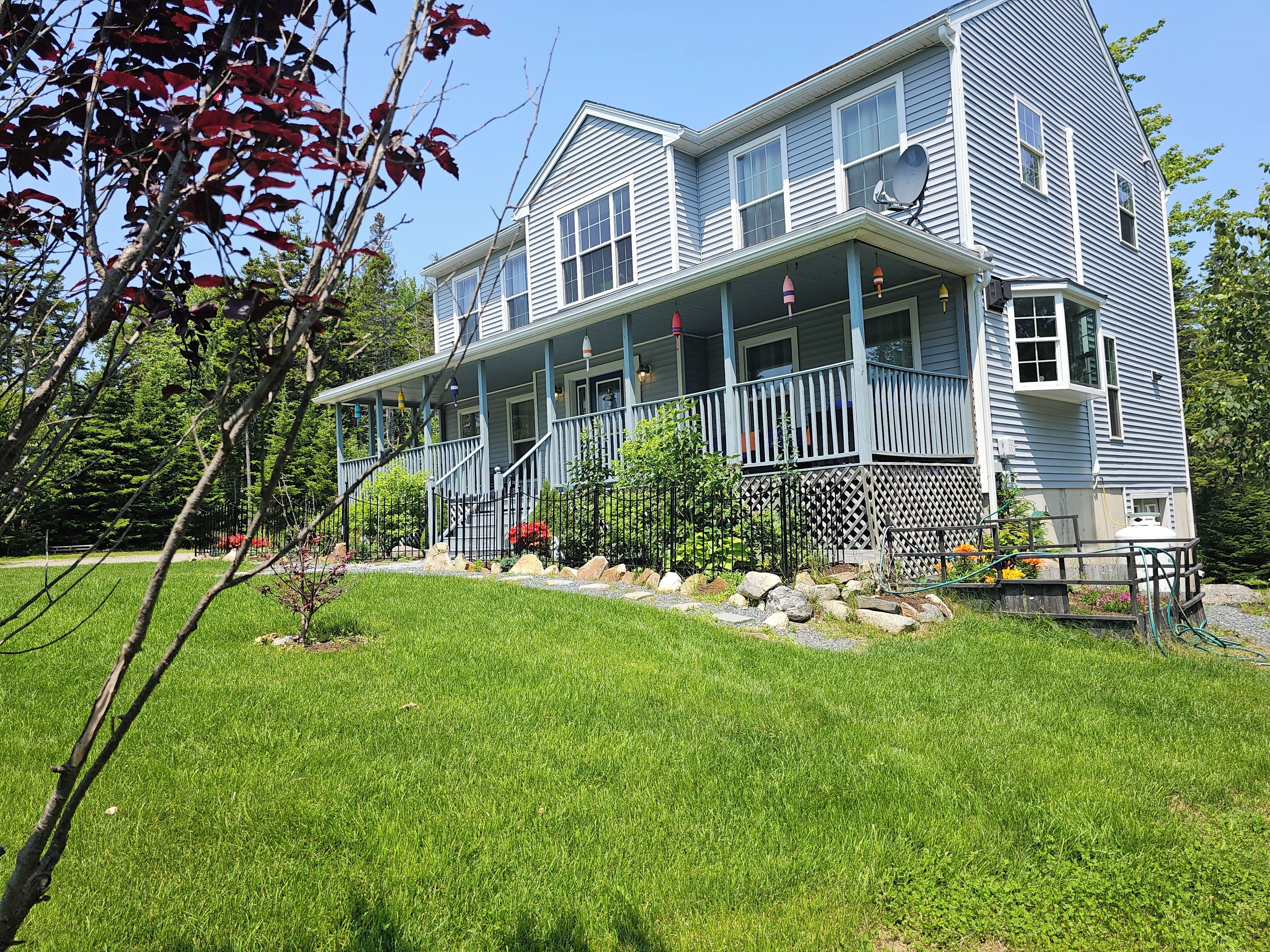 A two-story house with a covered porch and a well-maintained lawn.