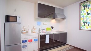 A compact kitchen with a microwave, refrigerator, and a small sink area. - SC1 Kaikanoyado (Osaka)