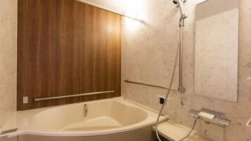 A modern bathroom with a freestanding bathtub, a shower, and a wall-mounted mirror.