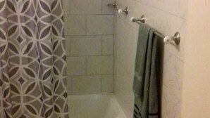 Ein Badezimmer mit Dusche, Toilette und Handtuchhalter.