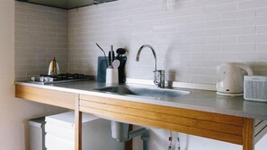A modern kitchen with white cabinets, a stainless steel countertop, and a built-in gas stove.