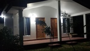 A house with a covered porch, two doors, and a small garden area with plants. - JEYs Place (Nilaveli)