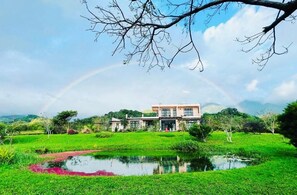 A house with a pond in the foreground and a rainbow in the background. - Moshang Caoxun (Changbin)