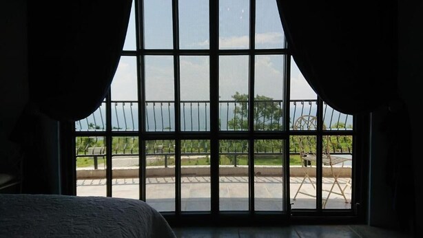 A room with a large window, curtains, and a view of an outdoor area with a fence and a bench. - Moshang Caoxun (Changbin)
