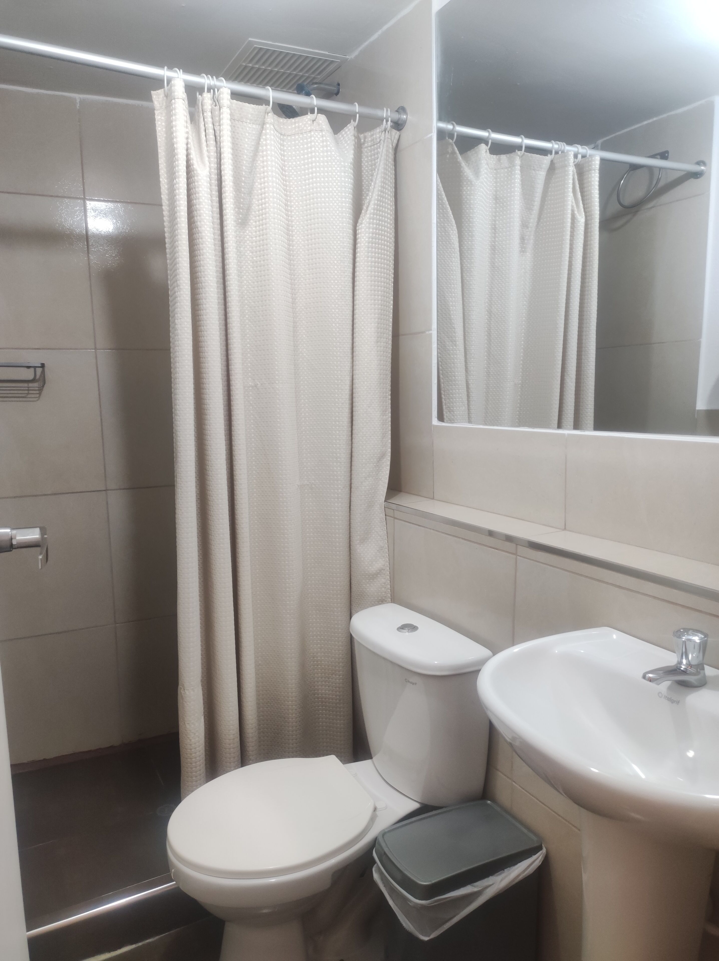Un baño con inodoro, bidé y lavamanos.