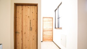 A hallway with a wooden door and a window. - Tree House Café & Homestay (Tongluo)