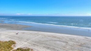 A beach with a wide sandy shore, gentle waves, and a clear blue sky. - Sea Pointe 906-Oceanfront 1BR-Indoor Pool-Hot Tub (NORTH MYRTLE BEACH)