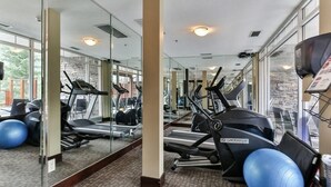 A gym with treadmills, elliptical machines, and exercise balls.