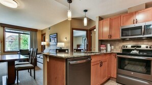 A modern kitchen with wooden cabinets, a built-in oven, a microwave, and a dishwasher.
