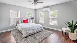 A bedroom with a bed, a ceiling fan, and a large window. - Beautiful, Renovated, Cozy & Quiet Vacation Home in Central Houston! (Houston)