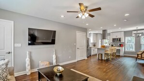 A modern kitchen with a central island, white cabinets, and a microwave. - Beautiful, Renovated, Cozy & Quiet Vacation Home in Central Houston! (Houston)
