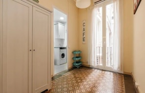 A hallway with a washing machine, a teal cart, and a 'CAFE' sign.