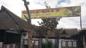 Señal de Half City Bar Lounge & Grill, que indica que está abierto las 24 horas.