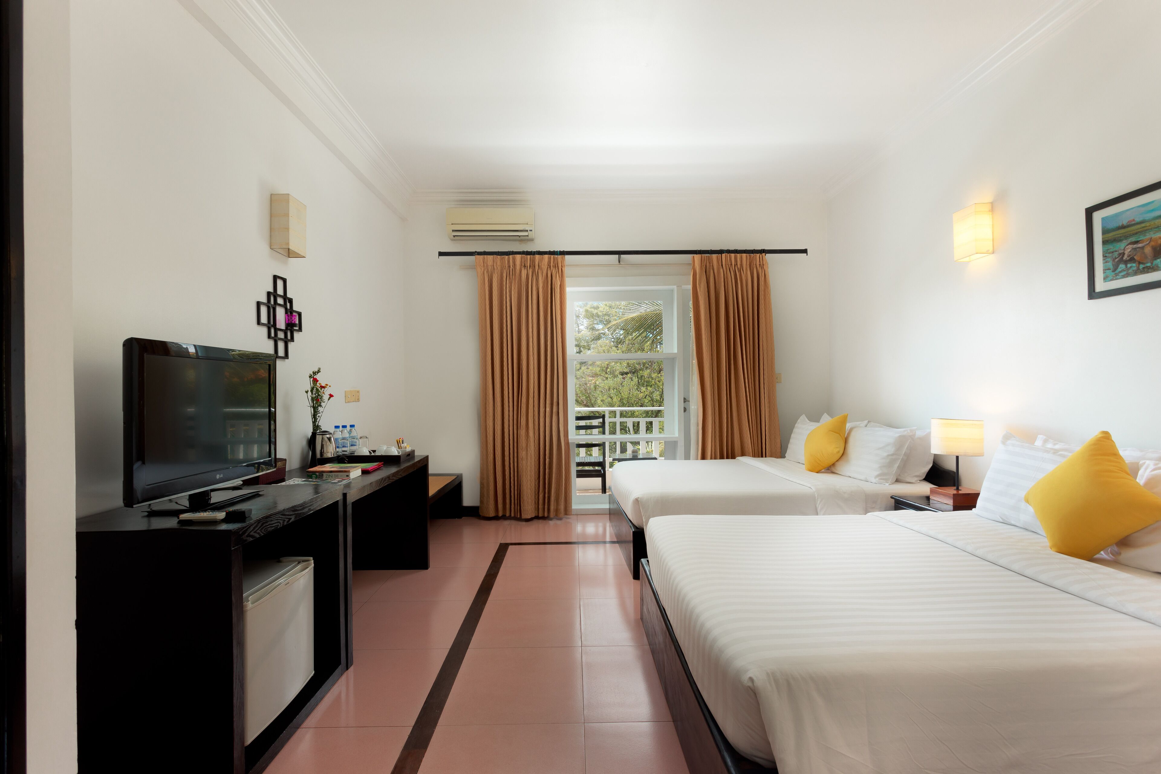 A hotel room with a TV, desk, two beds, a window with curtains, and a painting on the wall.