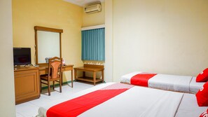 A hotel room with a desk, a chair, a bed, and a television. - OYO 2085 Chrysanta Hotel (Bandung)