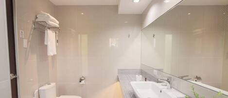 Un baño moderno con inodoro, lavabo y ducha.