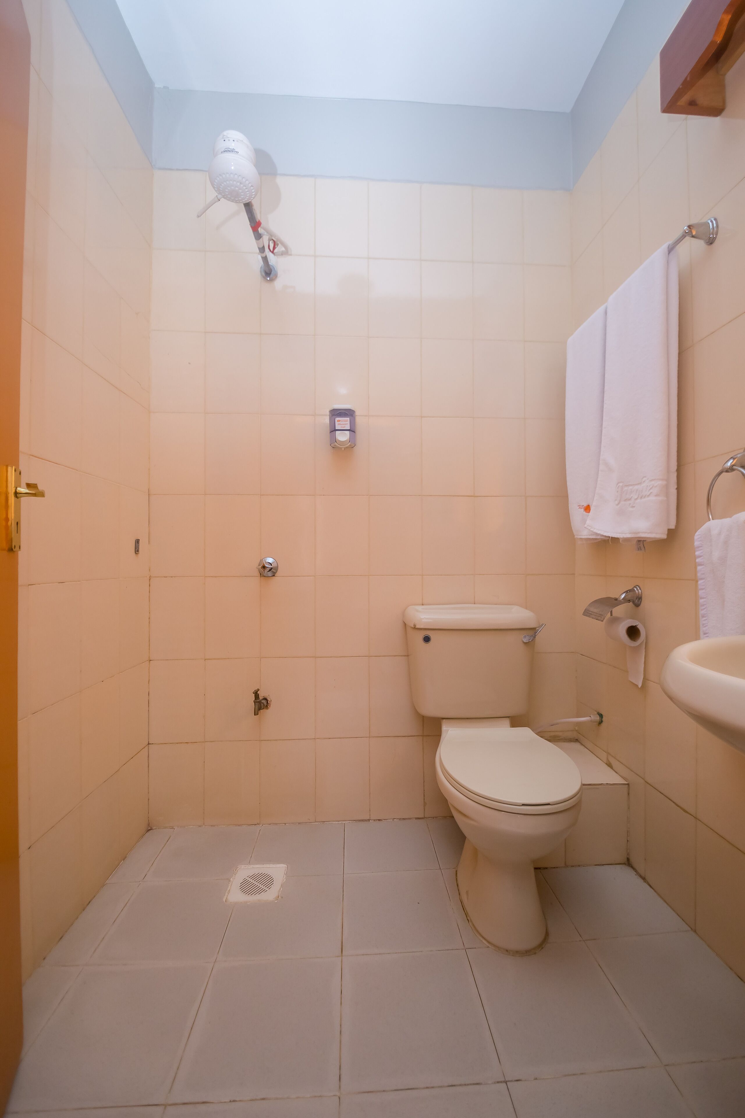 Pieni kylpyhuone, jossa on wc, pesuallas ja suihku.