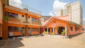 Un hotel con recepción, varios pisos y un patio empedrado.