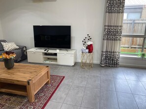 Relax in this stylish living room with a flat-screen TV, coffee table, and comfortable seating area.