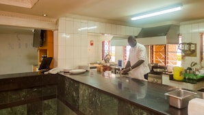 Una cocina con encimera de mármol, un lavabo y diferentes utensilios de cocina.