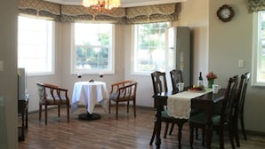 A dining area with a table set for four, surrounded by wooden chairs. - Dasom Pension (Seogwipo)
