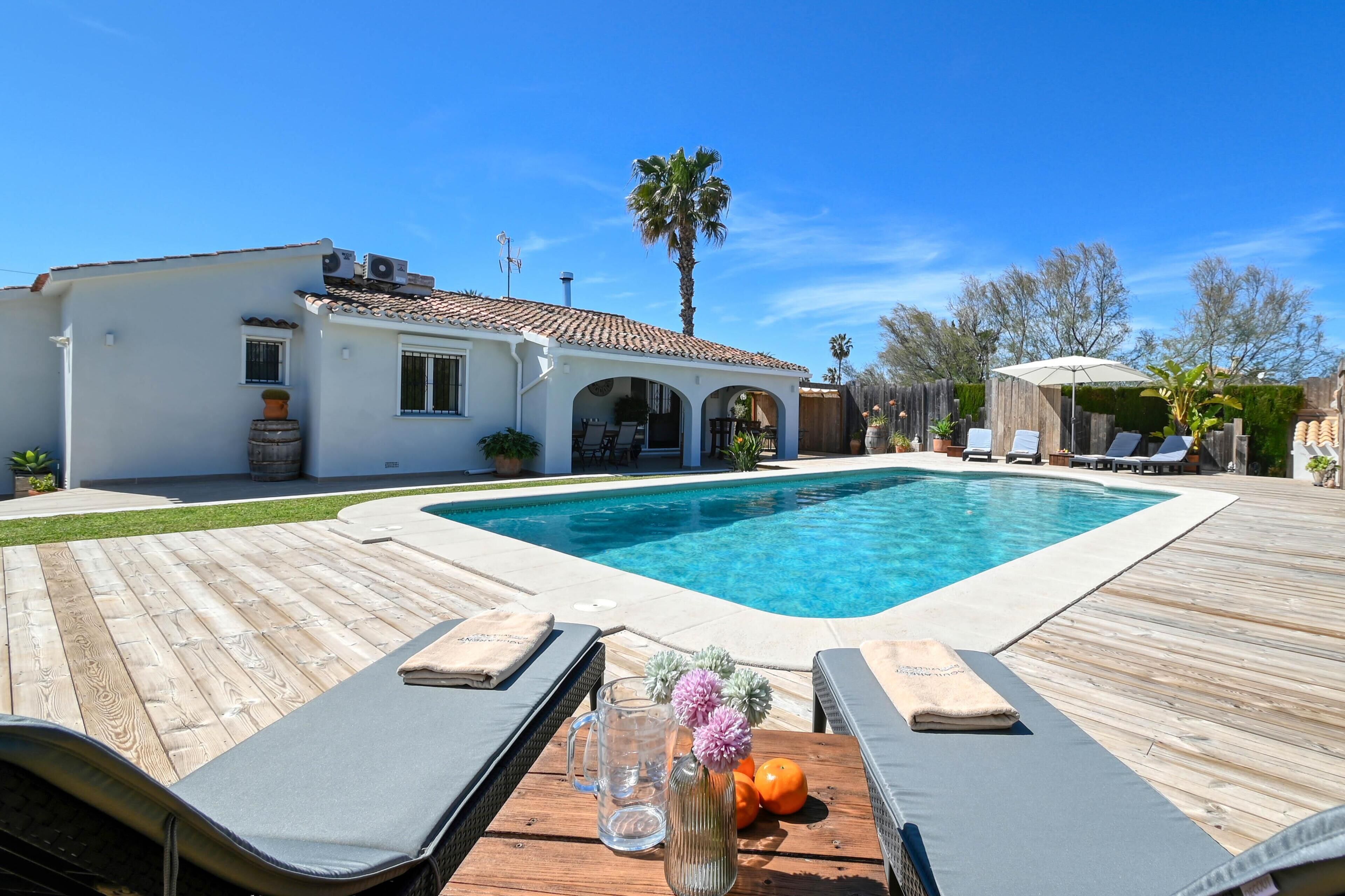 Une piscine avec des chaises longues et une terrasse en bois.