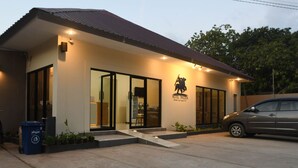 Un hotel de diseño moderno, con una amplia entrada de vidrio, un logotipo con un jinete a caballo y un coche estacionado al frente.