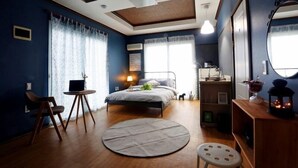 Ein Schlafzimmer mit Bett, Nachttisch, Lampe und einem runden Teppich.
