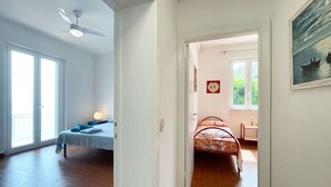 A room with a bed, a desk, a chair, a window, and a ceiling fan. - Villa Porticciolo - Villa with a wonderful sea view in Rio Marina - ibookingelba (Rio Marina)