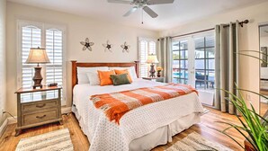 A bedroom with a bed, nightstands, a ceiling fan, and a view through the window. - Heated Pool, Views, & Trail Access: Phoenix Escape (Phoenix (Ahwatukee))