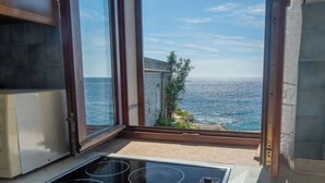 A kitchen with a view of the sea through large windows. - Apartments Hinterreiter (Rovinj)