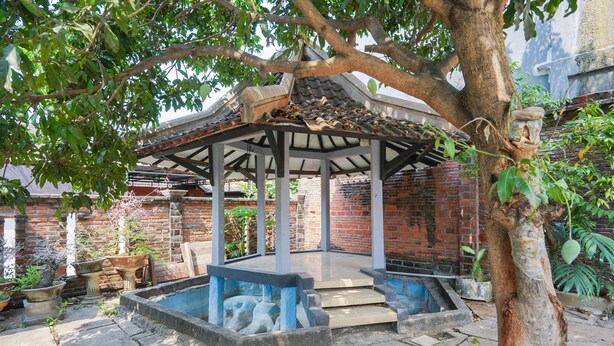 A gazebo with a tiled roof, surrounded by a brick wall and potted plants. - OYO 1439 Gang Guest Homestay Syariah (Tuban)